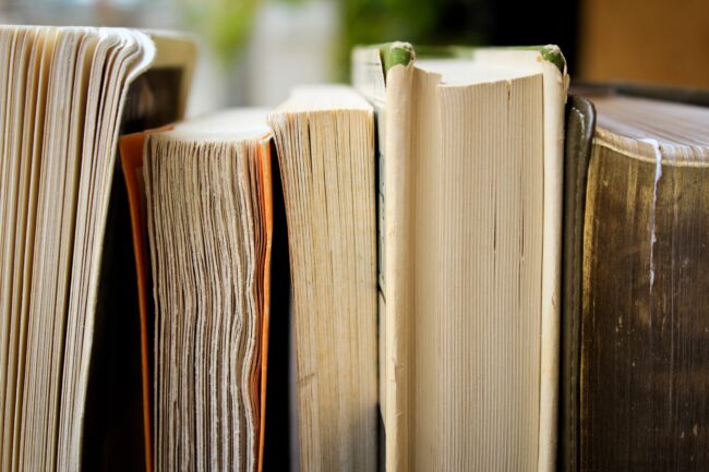 Glossary creation is an important step in the translation process. Description: weathered books on a shelf.