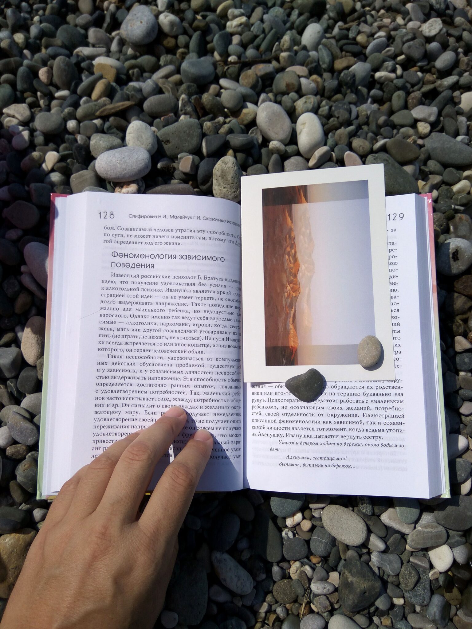 Transliteration is part of a wider translation strategy.

Description: A Russian book, open to a page with a bookmark, on a pebble stone beach with a hand holding it open.